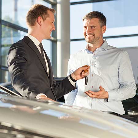 Sales man handing car key to customer